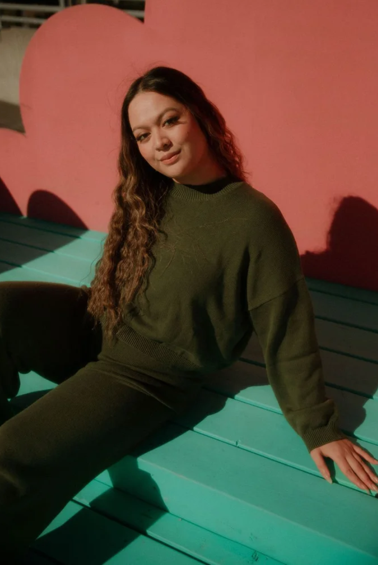 Woman wearing a forest green cropped crewneck sweater with the matching wide leg knit lounge pants.